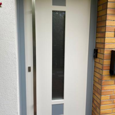 Einzelne Haustür mit farbigen Einsätzen und Glaselement